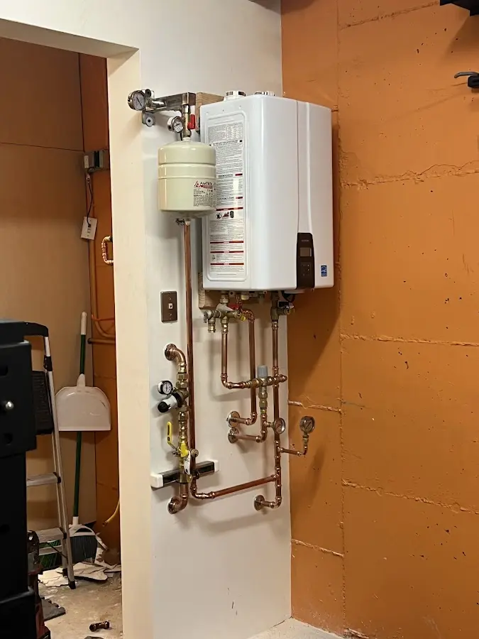 Plumbing technician inspecting water heater connections in Orwigsburg